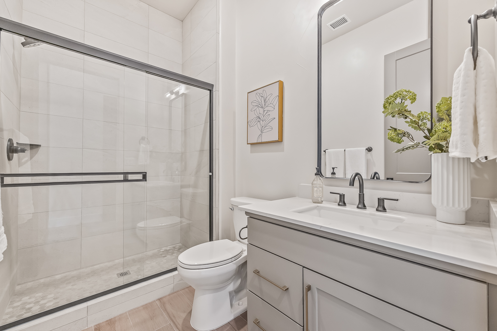 wide angle of bathroom 3 with single vanity, toilet, and shower