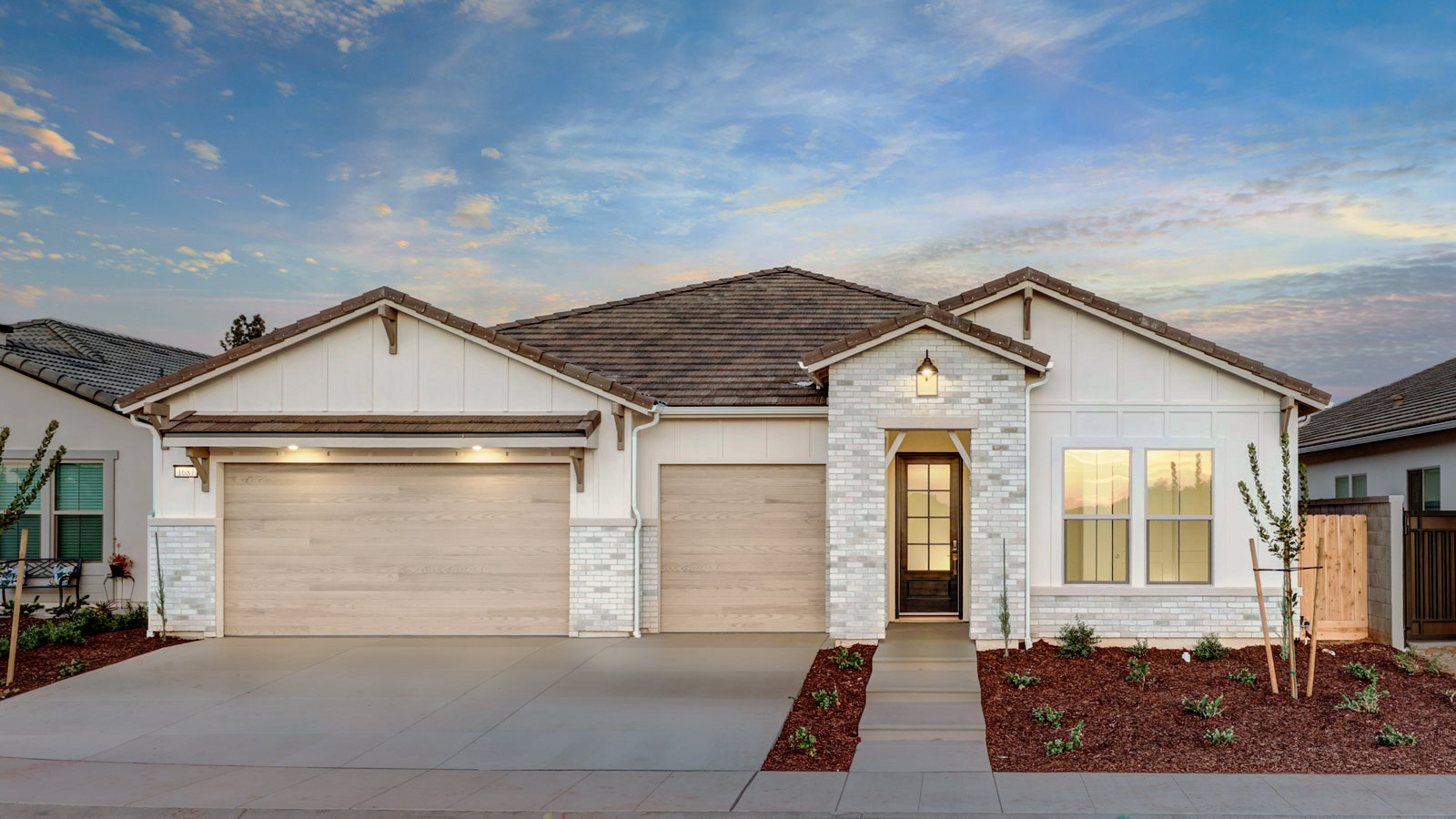 Photo of a Granville Bella home with white siding, white brick accents, and a light wood-colored garage door