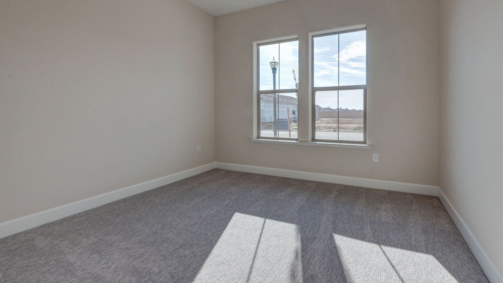 Empty bedroom with two windows