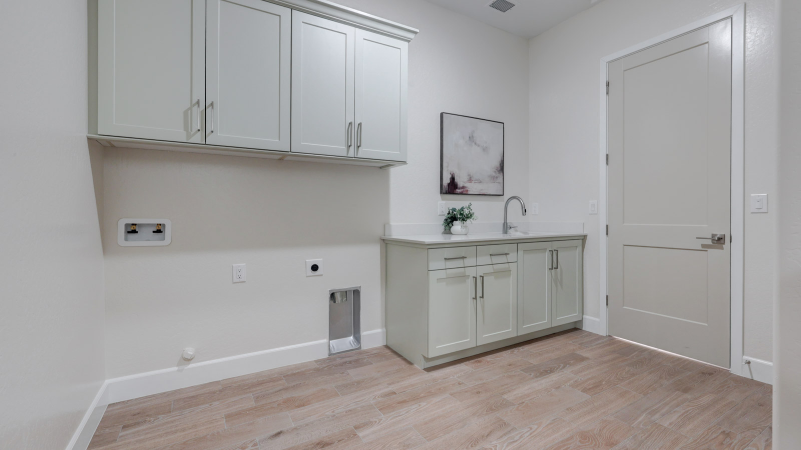 Laundry with sink, abundant cabinets and closet.