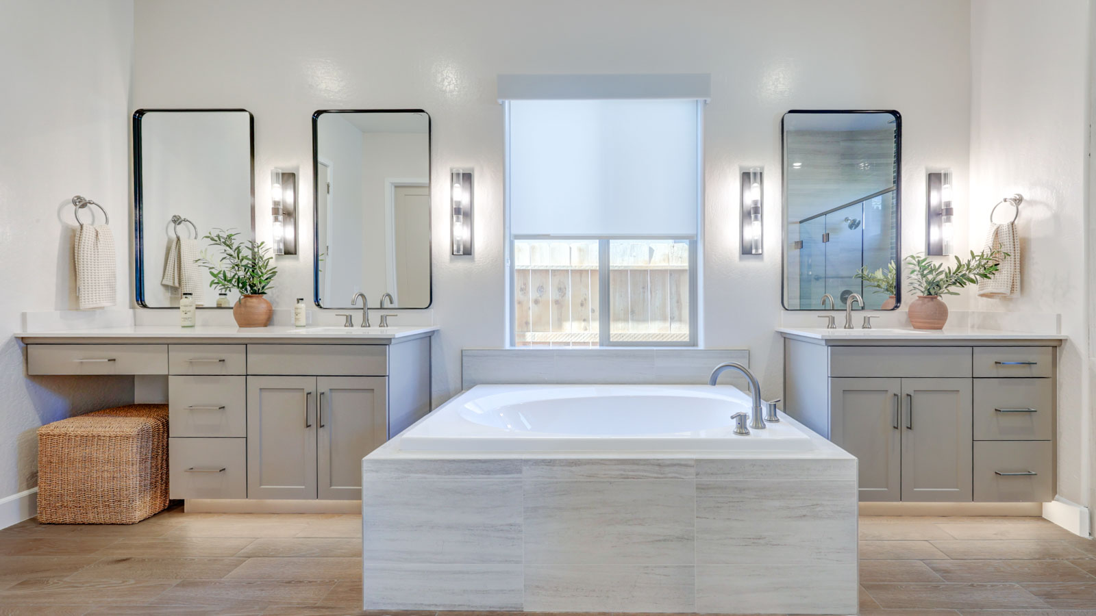 Owner Bath with separate tub and shower, two vanities and plank tile flooring.