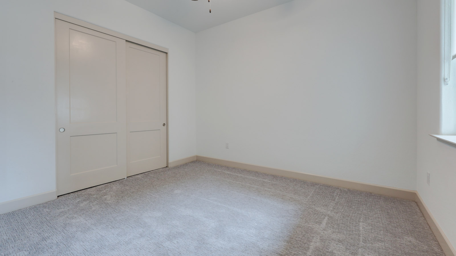 Bedroom with carpet and window blinds and adjoining bath