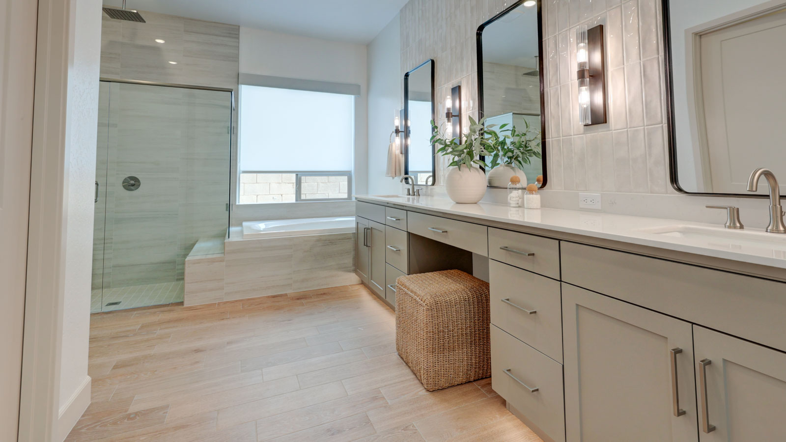 Spacious bath with multi-head shower, stylish tub, and long spacious vanity.