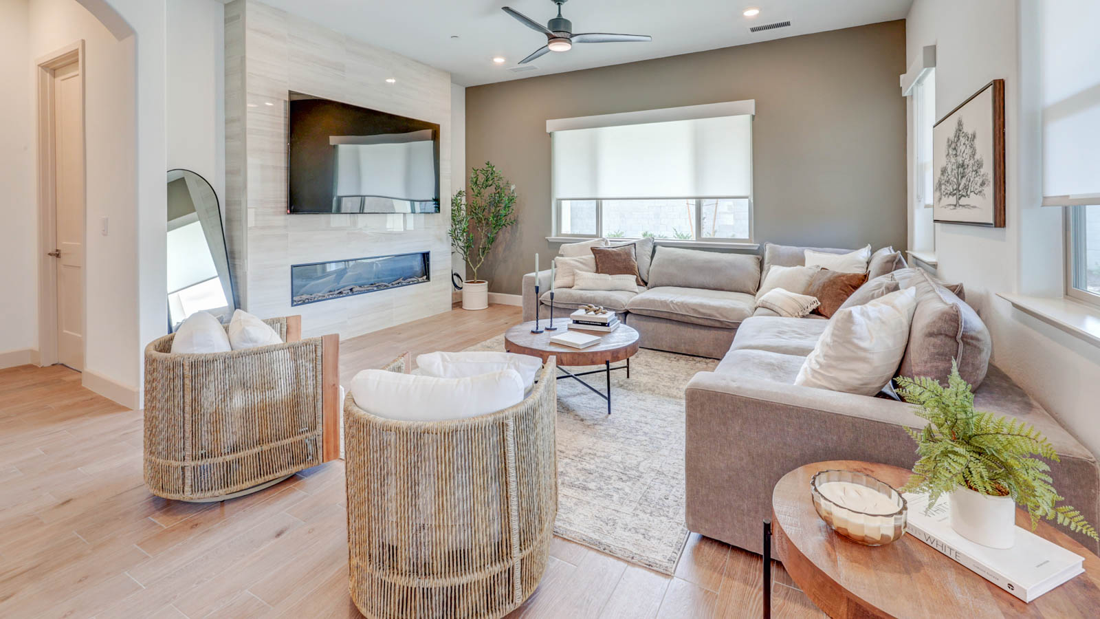 Great room with TV above electric fireplace.