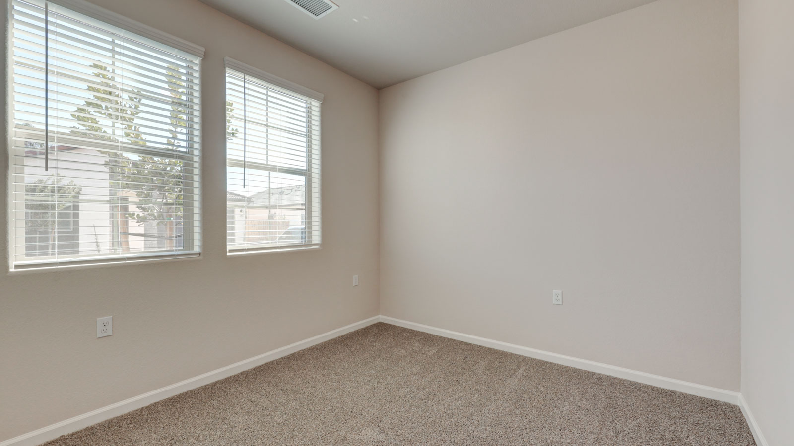 Bedroom with two windows and carpeting