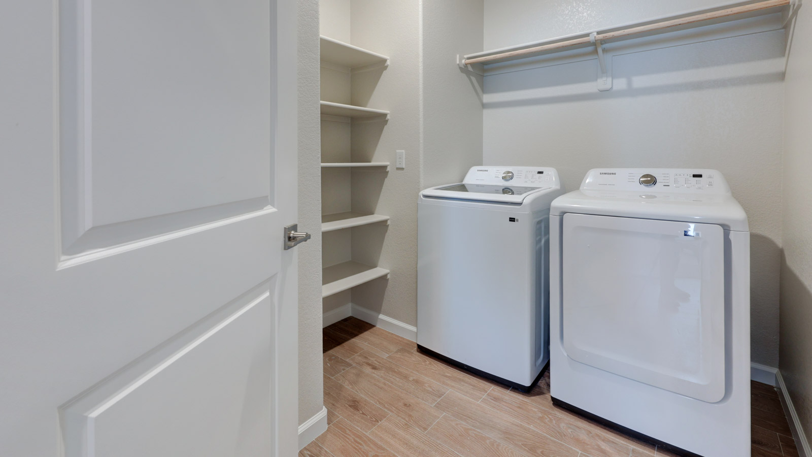 Laundry with coat closet, shelving, and washer and dryer