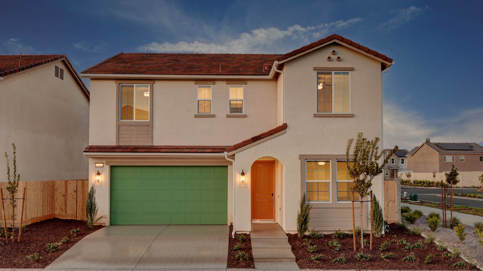 Home exterior with green garage door, orange door, cream colored stucco