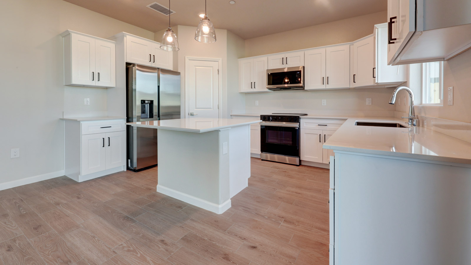 Kitchen with white cabinets, island and tile flooring