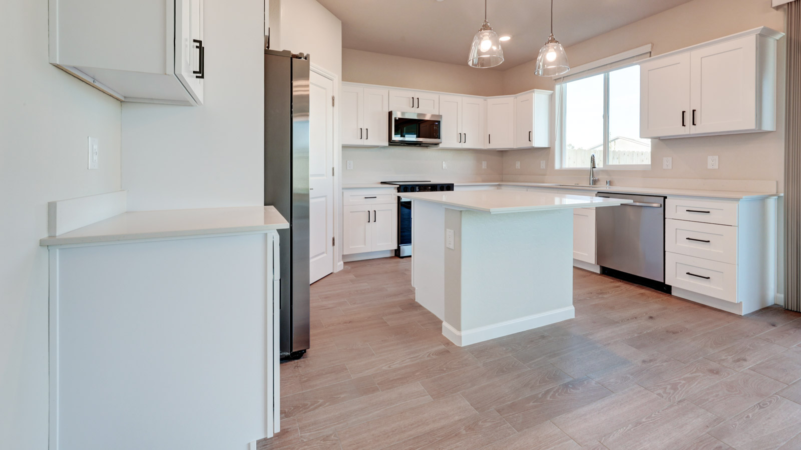 Kitchen with white cabinets, island and tile flooring