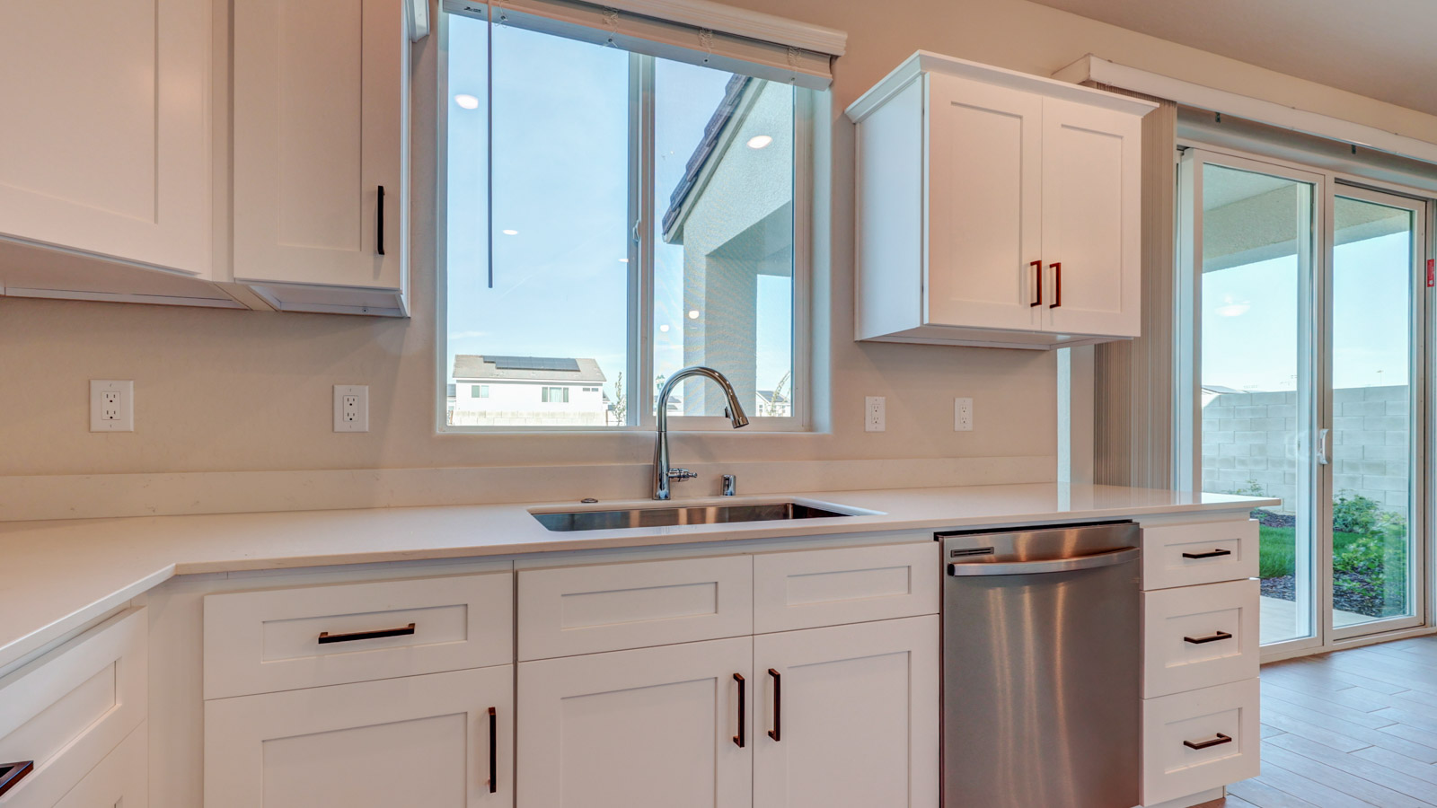 Sink and Dishwasher with quartz counter and window above the sink.