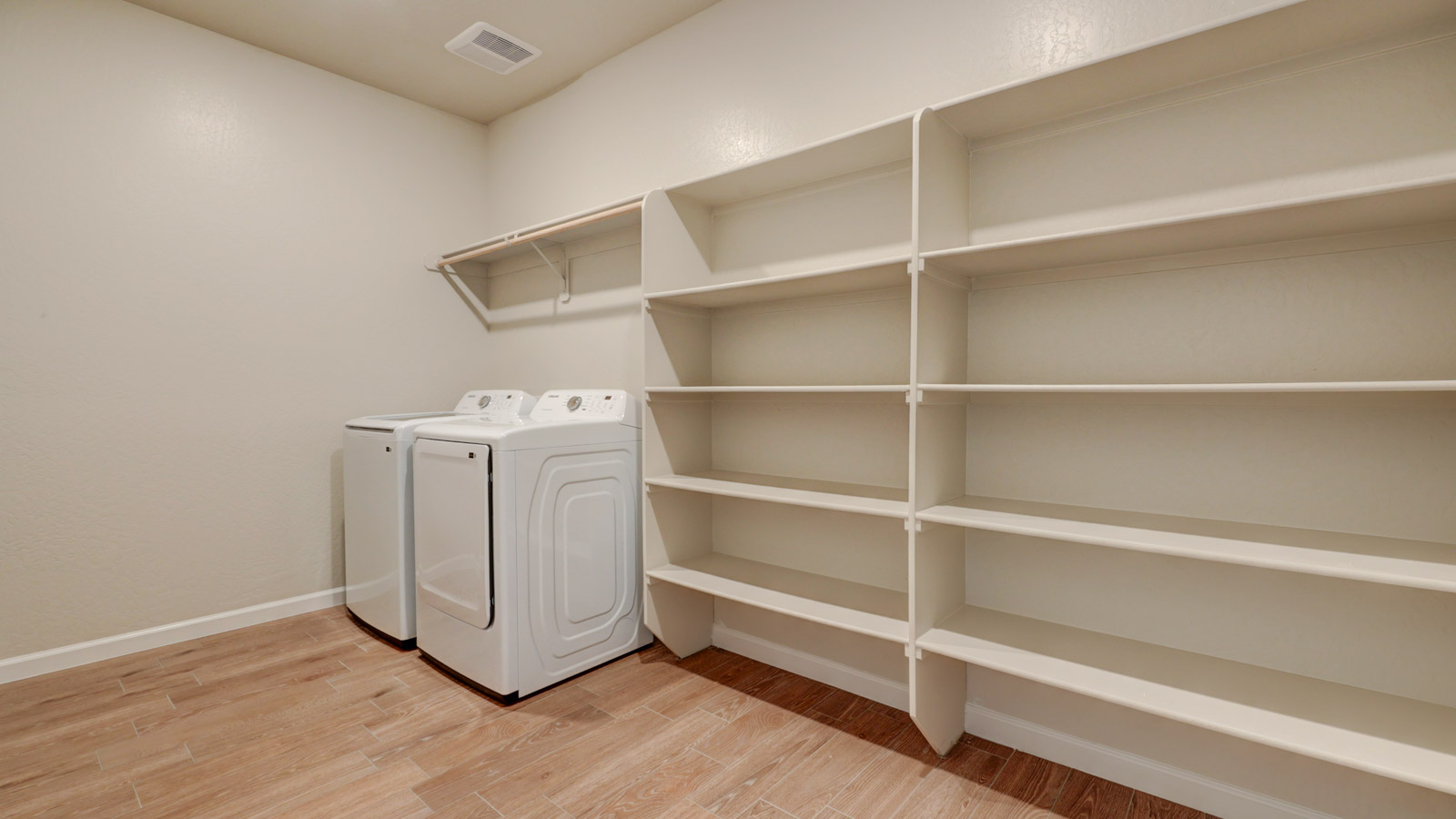 Laundry with abundant shelving and Samsung washer and dryer
