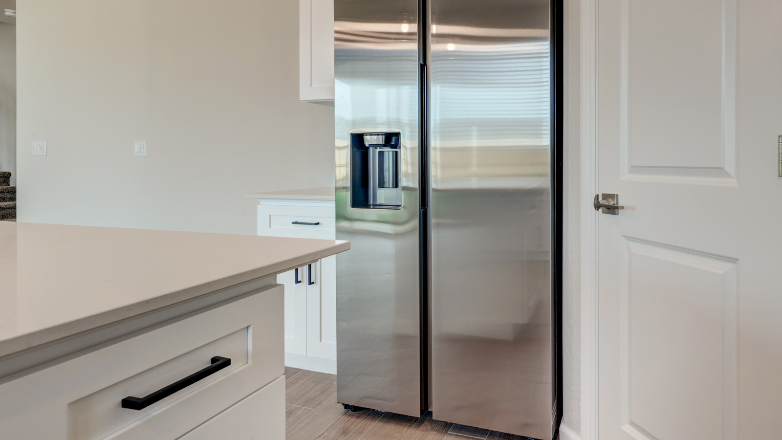 Kitchen with white cabinets, walk-in pantry and tile flooring